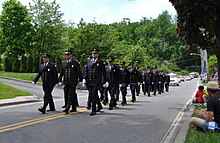 Uniformed men marching down a street