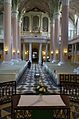 interior of the church, view to the organ, light pink columns, grey benches, dark green ornaments on the floor, organ case white and gold