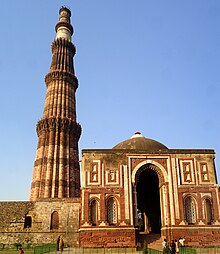 The Qutb Minar (left, begun c. 1200) next to the Alai Darwaza gatehouse (1311); Qutb Complex in Delhi Qutab Minar mausoleum.jpg