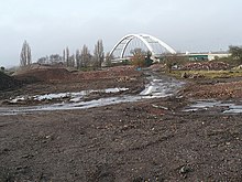 A cleared building site with the City Bridge in the background