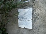 Le nom de l'église Sainte-Colombe inscrit sur une plaque en marbre blanc.