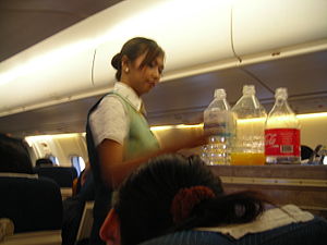 PBair female flight attendant at work on board...