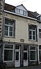 Huis met lijstgevel, voorzien van kozijnen van Naamse steen.