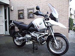 A silver BMW R1150GS parked on the driveway of a house