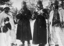 Finnish cavalrymen guarding two Red Army soldiers in Lemetti in the Ladoga Karelia. Red Army POWs in Winter War.png