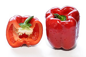 A whole and halved red bell pepper