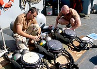 Des militaires de l'US Navy appartenant à l'Explosive Ordnance Disposal Mobile Unit Two (EODMU-2) vérifiant leur équipement de plongée (Golfe Persique, 2003).