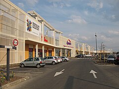 Vue d'une enfilade de devantures de magasins dans une zone commerciales.