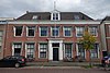 Herenhuis "Overpost". Herenhuis met een verdieping en houten kroonlijst. Deuromlijsting met gecanneleerde pilasters met Jonische kapitelen. Vensters met zes- en vierruitsschuiframen. Het oplopende pannenschilddak is in 1987 toegevoegd.