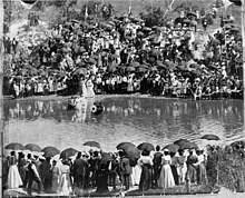 A large group of African-American spectators stands on the banks of Buffalo Bayou to witness a baptism (ca. 1900). Baptism in Buffalo Bayou.jpg
