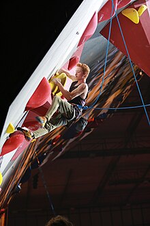 Ein Kletterer („Trevor Smith“) klettert eine Indoor-Route. Der rechte Unterarm ist kurz nach dem Ellenbogen amputiert.