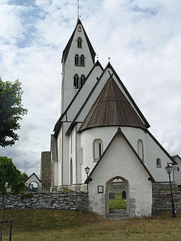 Gothems kyrka sedd från långhussidan, med en av de medeltida stigmurarna i förgrunden.