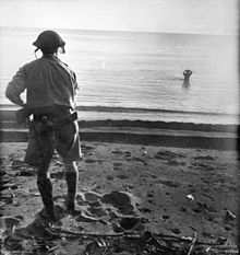 A Japanese soldier in the sea off Cape Endaiadere, New Guinea, on 18 December 1942 holding a hand grenade to his head moments before using it to commit suicide. The Australian soldier on the beach had called on him to surrender. Japanese soldier suicide Cape Endaiadere.jpg