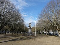 2 rangées d'arbres alignés de part et d'autre d'une large allée, avec au centre le monument aux morts.