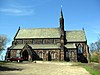 A stone church seen from the south, with a bellcote on the junction of the nave and chancel