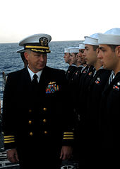 An officer inspects enlisted sailors in Service Dress Blue (2008) US Navy 080218-N-5476H-007 Cmdr. Richard Martel, executive officer of the guided-missile cruiser USS Lake Erie (CG 70), inspects the dress blue uniforms of Sailors during a uniform inspection on the flight deck prior to a buria.jpg