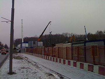 Вид на строительную площадку с нечётной стороны улицы Дыбенко. На фоне будущей станции виден Химкинский лесопарк. Январь 2014 года