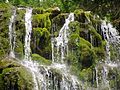 Water splashing over mossy rocks. Close-up of waterfall along the "La Chute" hiking trail