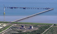 Aerial image of the site of the terminal, showing coastline and an offshore windmill to the side