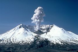 Volcan éventré au centre duquel se trouve un dôme d'où s'élève un panache de cendres.