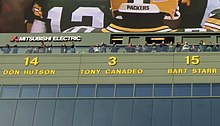 A photo of the retired numbers above the stands at Lambeau Field. Tony Canadeo's #3 is the focus of the image.