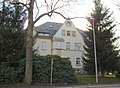 Mietshaus in offener Bebauung in Ecklage, mit Vorgarten entlang beider Straßen (ehemals Gemeindeamt und Sparkasse von Neustadt)