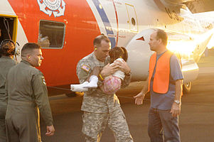 US Army Lieutenant Colonel Hector Paz carrying an injured girl to receive medical treatment after being evacuated from Port-au-Prince