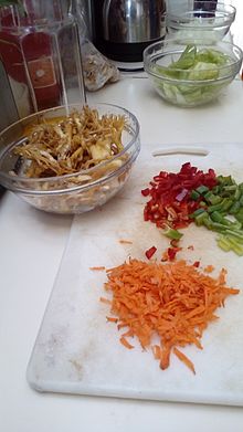 Preparación de un sofrito consistentes en zanahorias, cebollines, pimientos rojos, y changles.