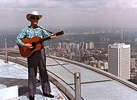 1980 colour photograph of Donn Reynolds performing outside atop the main deck roof of the CN Tower (Toronto, Ontario, Canada).