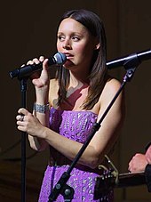 Hillary Lindsey performing with a mic on her hand.