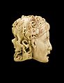 Різьблена фігурка зі слонової кістки, що демонструє обличчя людини з одного боку і череп - з іншого