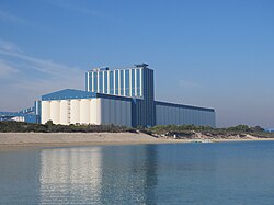 An enormous group of grain silos near a beach