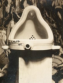 Marcel Duchamp Fountain, 1917, photograph by Alfred Stieglitz at 291 (art gallery) following the 1917 Society of Independent Artists exhibit, with entry tag visible. The backdrop is The Warriors by Marsden Hartley. Marcel Duchamp, 1917, Fountain, photograph by Alfred Stieglitz.jpg