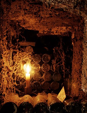 Old bottles of wine aging by candle light