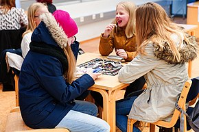 Young girls playing a board game in the Iisalmi library in Finland, 2016 Pelipaiva Iisalmen kaupunginkirjastossa.jpg