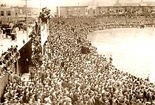 Fans watching the inaugural game, April 12, 1909. Somerset St. at left; 20th St homes at right. The A's prevailed over Boston, 8-1 Rooftopbleachers.jpg