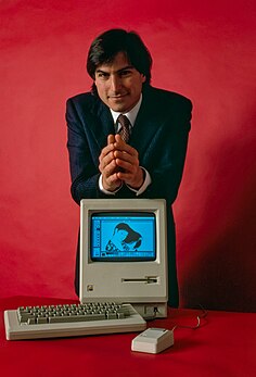 Steve Jobs posant derrière un Macintosh 128K, en janvier 1984. (définition réelle 3 340 × 4 918)