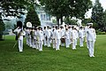 Captain George N. Thompson, commanding officer of the United States Navy Ceremonial Band, leads the Drum Major and band members as they render honors during a 21-gun salute at the swearing-in ceremony for Secretary of the Navy (SECNAV) the Honorable Ray Mabus at the Washington Navy Yard.