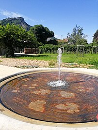 La fontaine du jardin avec le rocher de Saint-Loup en arrière-plan.