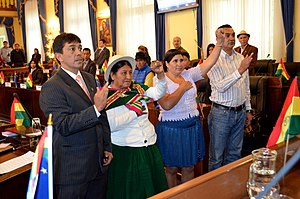 Los senadores levantan el puño izquierdo o levantan la mano al jurar ante la cruz mientras prestan juramentos.