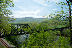 The رود جیمز is framed by crossing railway lines at Natural Bridge Station.