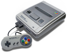 Console de jeux vidéo (boite grise avec une manette reliée, composée d'une petite boite grise avec des boutons de plusieurs couleurs).
