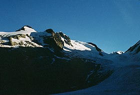 L'aiguille de la Bérangère et son glacier au soleil sur la gauche dominant le glacier de Tré-la-Tête dans l'ombre sur la droite de l'autre côté de la pointe des Conscrits.