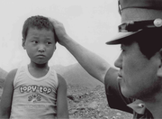 Boy nervously greets police officer after his family was killed in the Uiryeong Massacre (June 14, 1982)