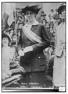 Photographie en noir et blanc d'une femme portant une écharpe politique blanche