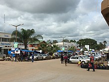 Downtown Kabwe, Zambia, wakitazama Njia ya Uhuru huku Mnara wa Kitaifa wa Mti Mkubwa (mtini mkubwa) ukionekana barabarani (upande wa kulia wa picha)