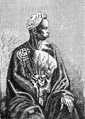 A Griot, who have been described as an endogamous caste of West Africa who specialise in oral story telling and culture preservation. They have been also referred to as the bard caste. GriotFete.jpg