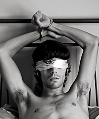 A man handcuffed to a bed and blindfolded Man Cuffed to Bedrail.jpg