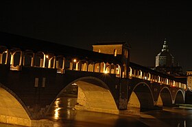 Il ponte coperto visto dalla sponda sud del fiume Ticino di notte.