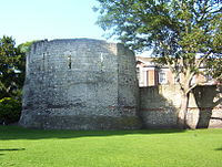 Roman wall and the west corner tower of Eboracum. The top half is medieval. Roman Fortifications in Museum Gardens York.jpg